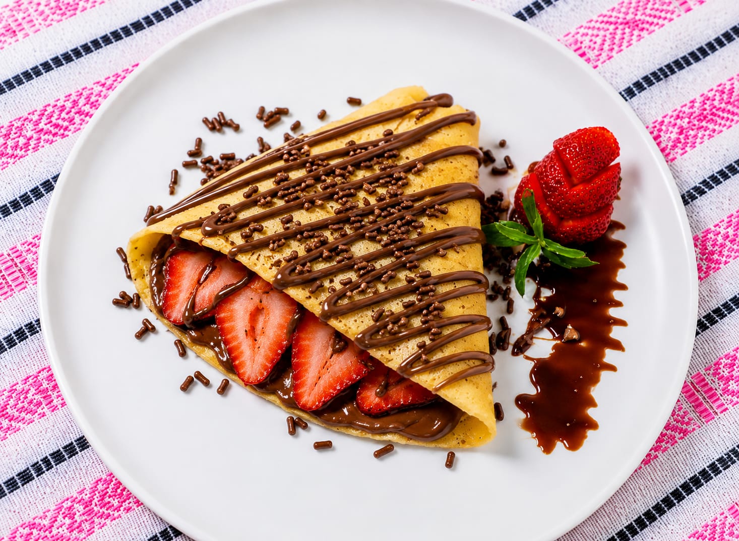 Crêpe Choco Berry Bliss con fresas frescas, Nutella, queso crema, chocolate líquido y granillo de chocolate